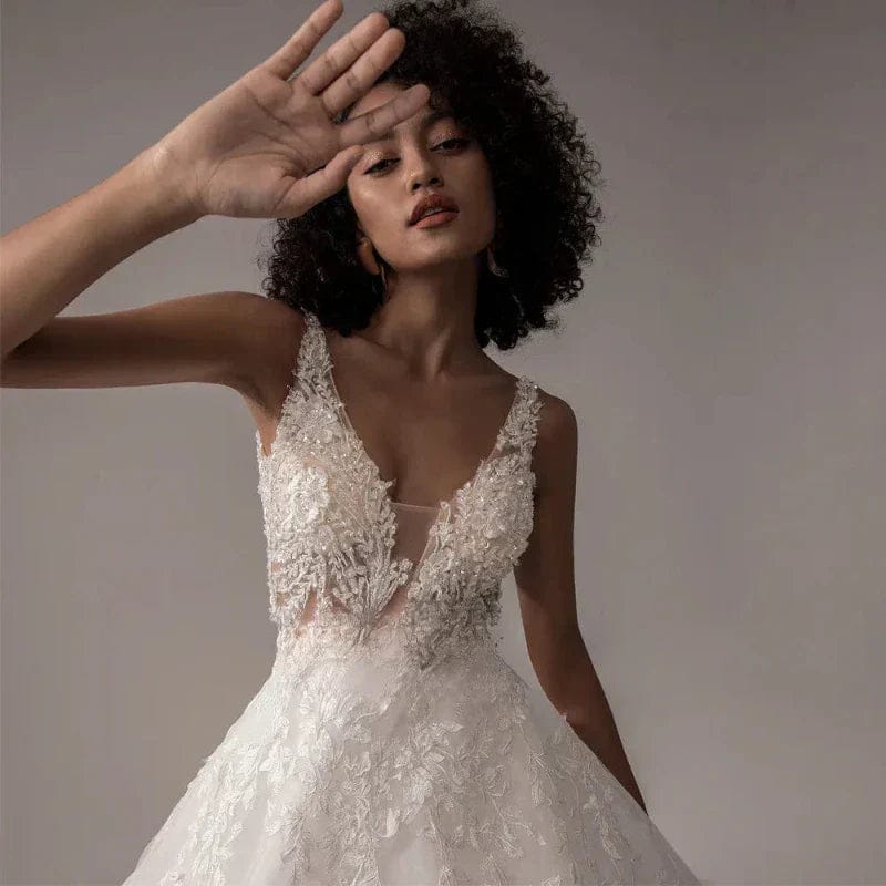 Woman wearing a white lace wedding dress against a neutral background